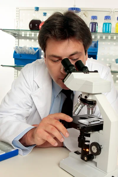 Naukowiec wyglądają na slajdzie pod mikroskopem — Zdjęcie stockowe