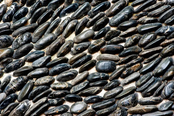 Black pebbles background — Stock Photo, Image