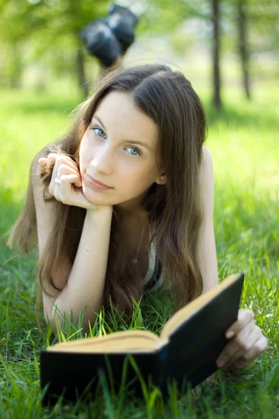 Jovem estudante ler livro no prado — Fotografia de Stock