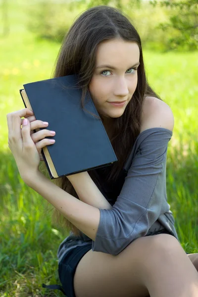 草地上的书的年轻学生 — 图库照片