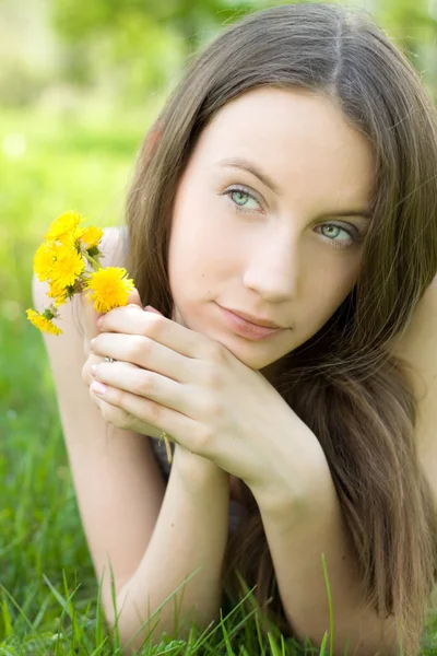 Молодий красивий підліток з кульбабою на газоні — стокове фото