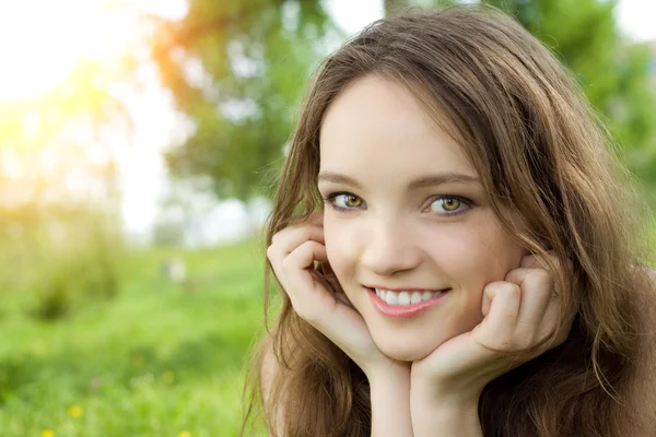 Młody nastolatek brunetka dziewczynka uśmiech na łące — Zdjęcie stockowe