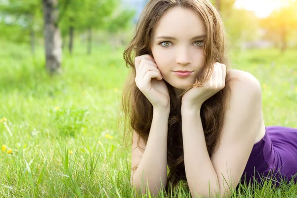 Young brunette teenager girl lying on meadow — Stock Photo, Image