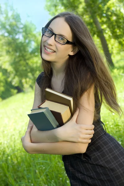 Chica joven estudiante feliz con libros en el parque —  Fotos de Stock