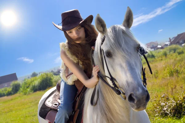 Молодой скотнице галопом на белом коне — стоковое фото