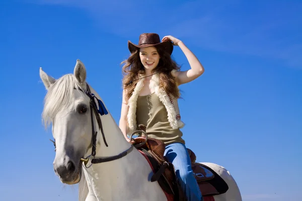 Jonge cowgirl op wit paard glimlach — Stockfoto