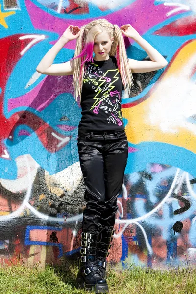 Woman at graffitti wall — Stock Photo, Image
