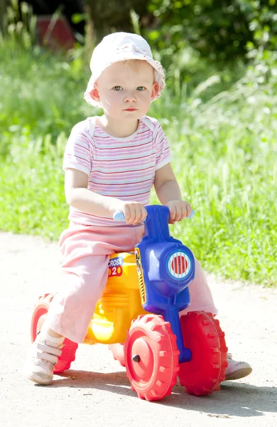 Girl on toy motorcycle — Stock Photo, Image