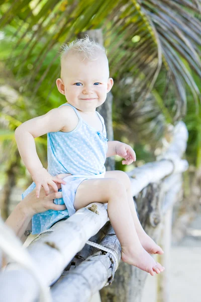 Palmiye ağacı üzerinde oturan toddler — Stok fotoğraf