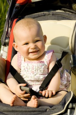 Baby girl sitting in a pram clipart