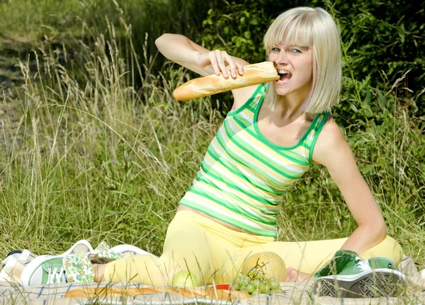 Woman eating baguette — Stock Photo, Image