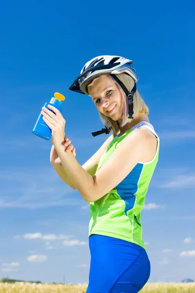 Biker using suntan lotion — Stock Photo, Image