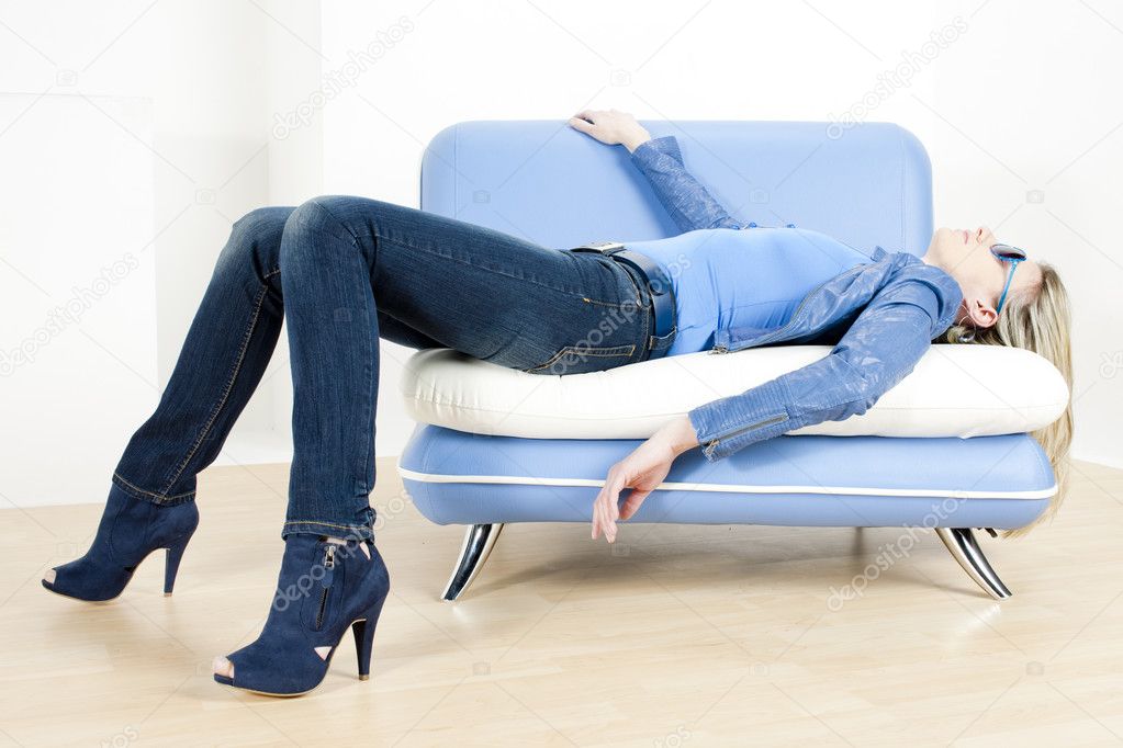 Woman wearing blue clothes lying on sofa