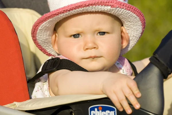Portrait of baby girl sitting in a pram — Stock Photo, Image