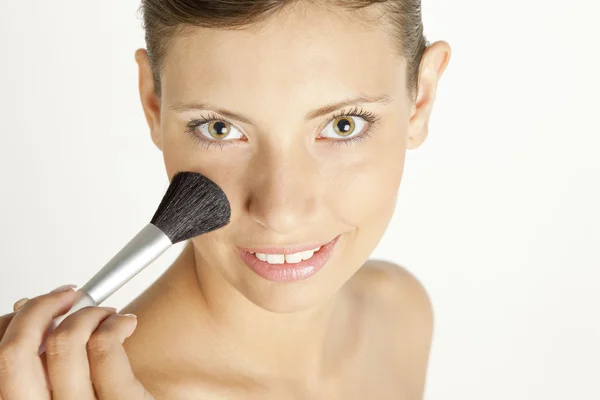 Mujer poniéndose polvo facial — Foto de Stock