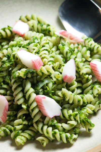 Pasta fussili with crab sticks and spinach — Stock Photo, Image