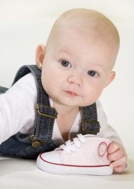 Baby girl holding a shoe clipart