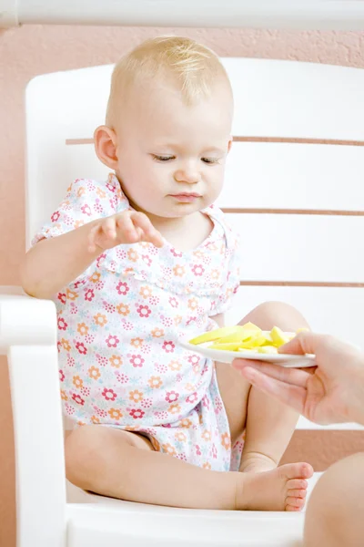 Сидящий малыш, поедающий яблоко — стоковое фото