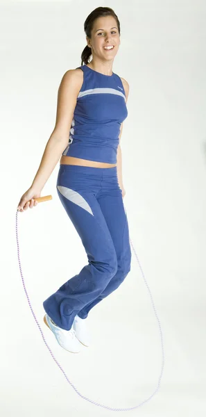 Mujer haciendo ejercicio con saltar la cuerda — Foto de Stock