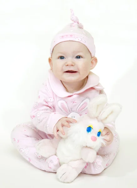Bir tavşan oyuncak bebek kız oturuyor — Stok fotoğraf