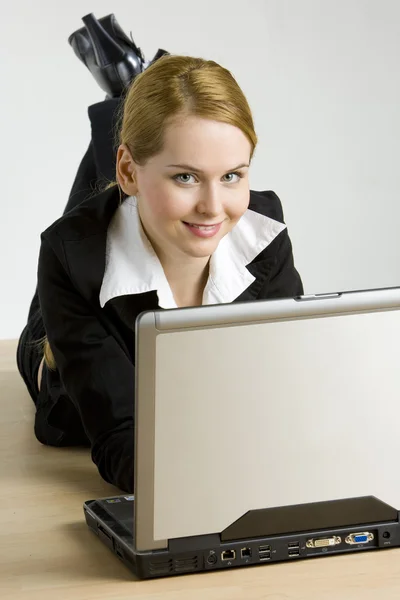 Liegen zakenvrouw met een laptop — Stockfoto