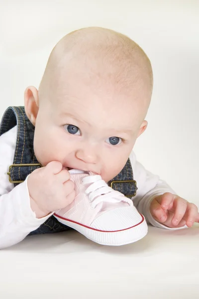 Meisje van de baby een schoen bedrijf — Stockfoto