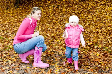 Mother with her daughter in autumnal nature clipart