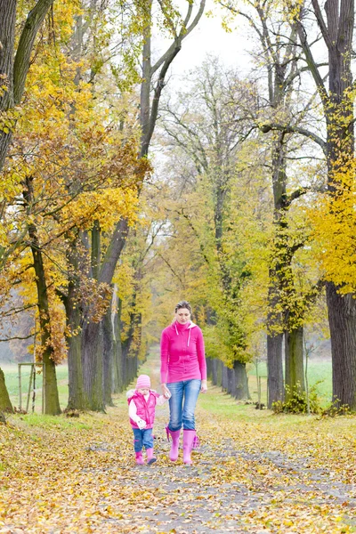 Moeder met haar dochter in herfst steegje — Stockfoto