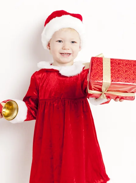 Kleines Mädchen als Weihnachtsmann mit Glocke und Weihnachtsgeschenk — Stockfoto