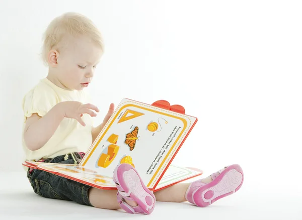 Sittande barn med en bok — Stockfoto