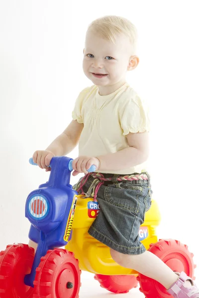 Kleines Mädchen auf Spielzeugmotorrad — Stockfoto