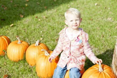 Little girl with pumpkins clipart