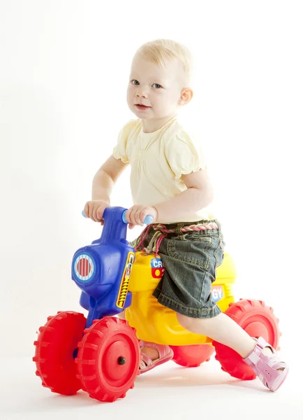 Маленькая девочка на игрушечном мотоцикле — стоковое фото