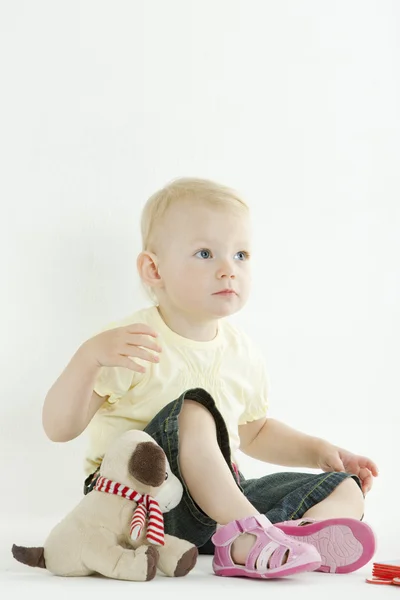 Sitzendes Kleinkind mit einem Spielzeug — Stockfoto