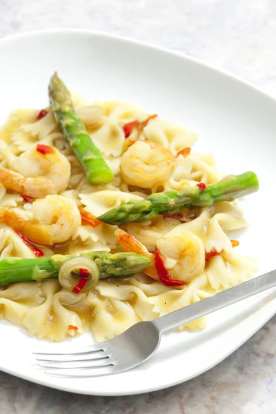 Hot pasta farfalle with asparagus and prawns — Stock Photo, Image