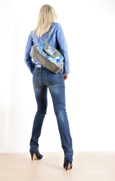 Mulher de pé vestindo roupas azuis com bolsa — Fotografia de Stock