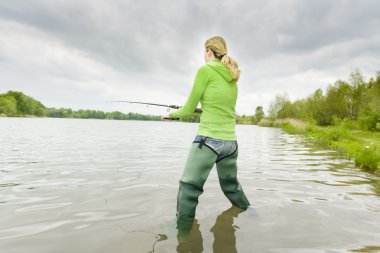 Woman fishing in pond clipart