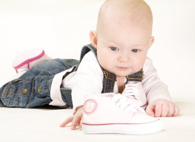 Baby girl holding shoes clipart