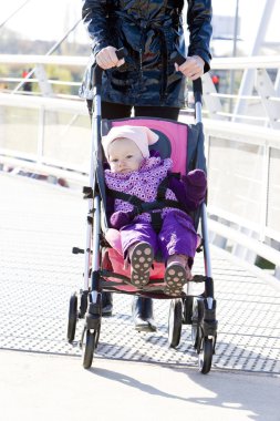 Woman with toddler sitting in pram on walk