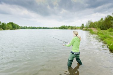 Woman fishing in pond clipart