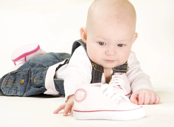 Baby girl holding shoes — Stock Photo, Image