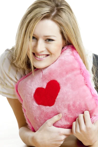 Mulher segurando um travesseiro com coração — Fotografia de Stock