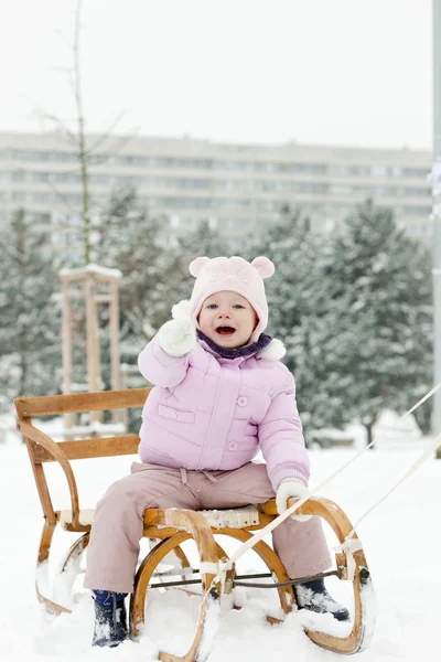 Liten flicka pulkaåkning i snö — Stockfoto