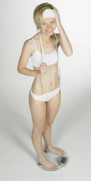 Kobieta noszenia bielizny stojący na skali wagi — Zdjęcie stockowe