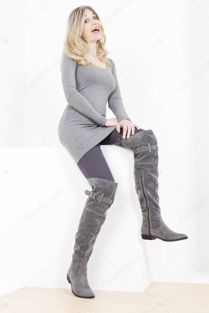 Sitting woman wearing fashionable gray boots