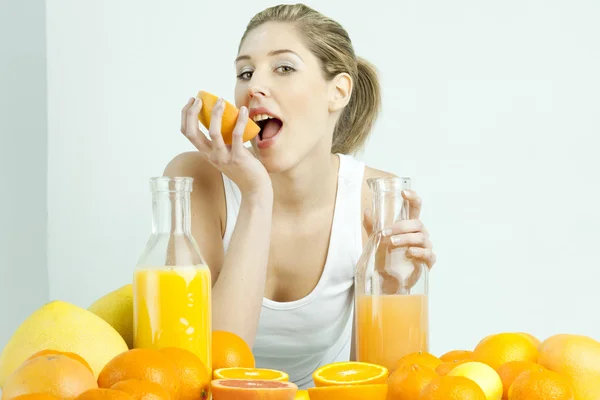 柑橘类水果和桔子汁的年轻女人的肖像 — 图库照片
