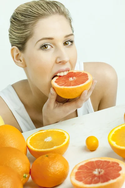 Portrait of young woman eating grapefruit — Stock Photo, Image