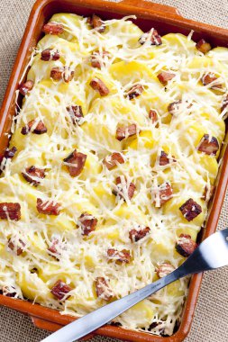 Potatoes and bacon baked with pecorino cheese clipart