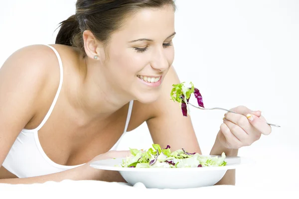 Ritratto di donna sdraiata che mangia insalata — Foto Stock