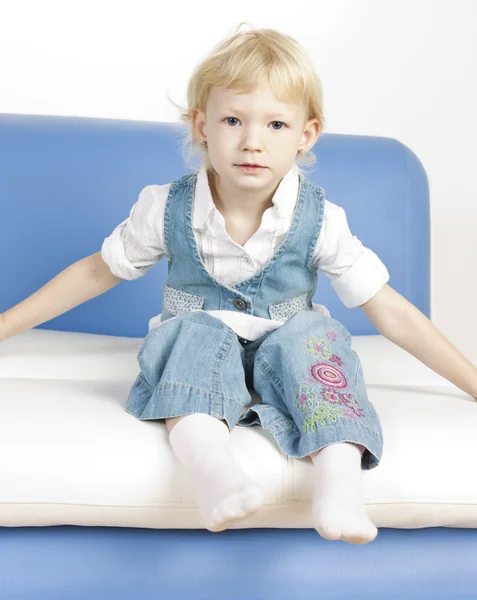 Little girl sitting on sofa — Stock Photo, Image